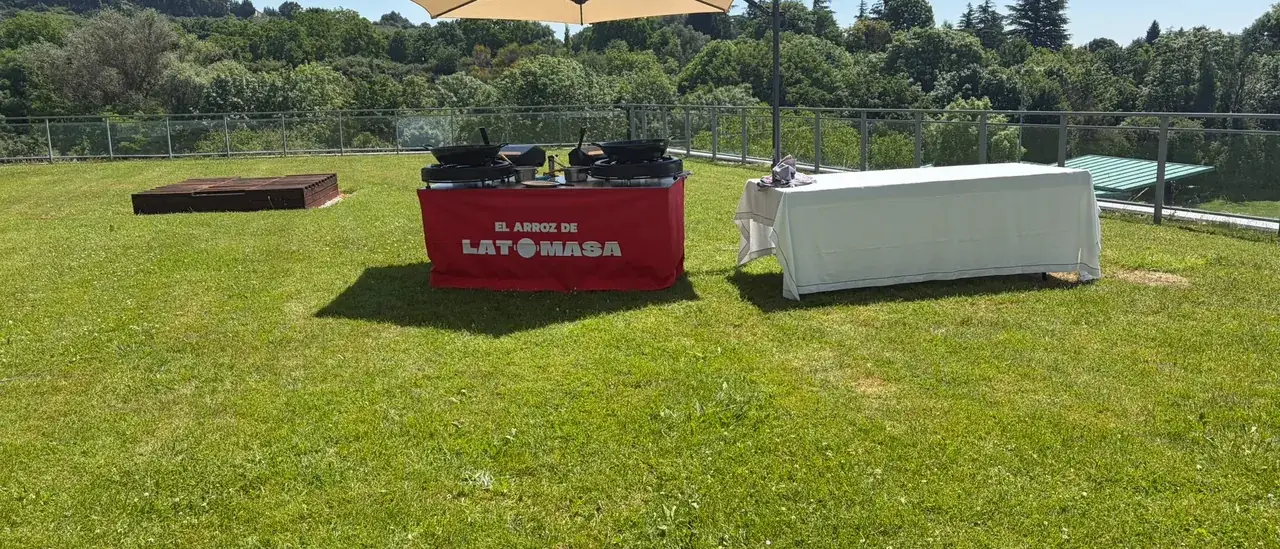 Montaje del servicio de paella de El Arroz de LaTomasa sobre el césped de una finca