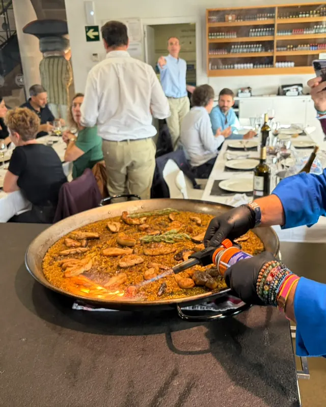 Paella terminada al soplete delante de los invitados en una comida de grupo