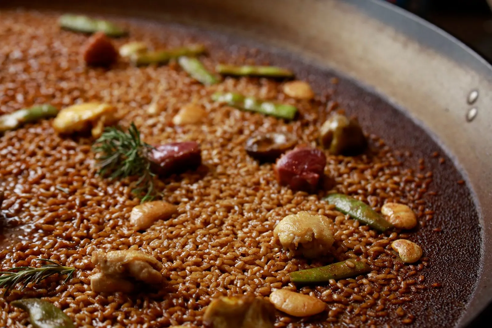 Paella Dinamita con socarrat tostado, ingredientes frescos y decorada con verduras en restaurante El Arroz de LaTomasa Pamplona.