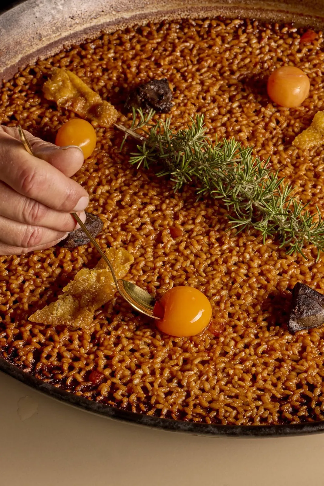 Detalle del arroz y socarrat perfecto en paella tradicional de acero pulido.